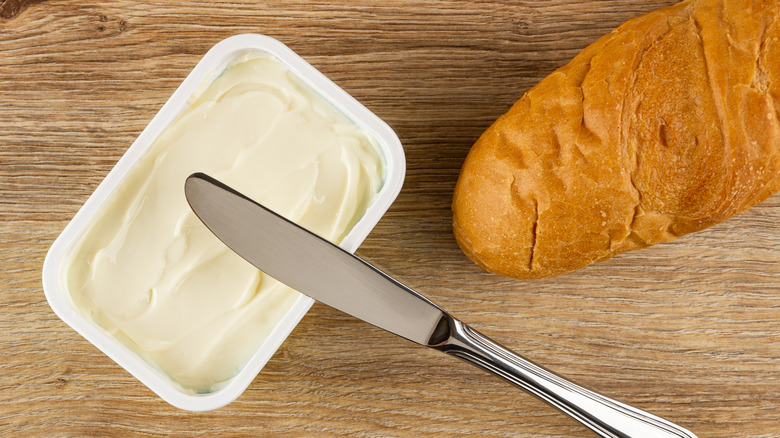 cream cheese with loaf of bread and knife