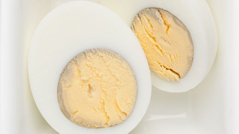 two hard boiled eggs with ring in white dish
