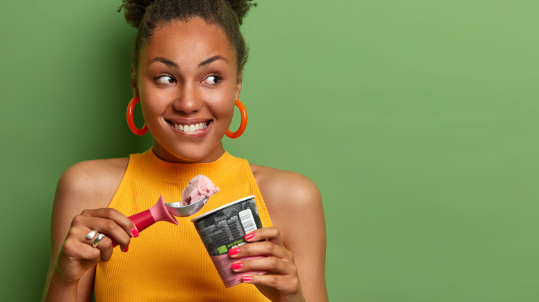 Woman eating pint of ice cream