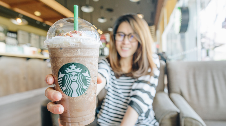 Woman holding a Starbucks drink