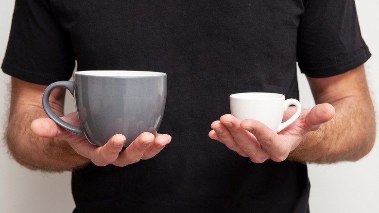 Man holding small and large cups