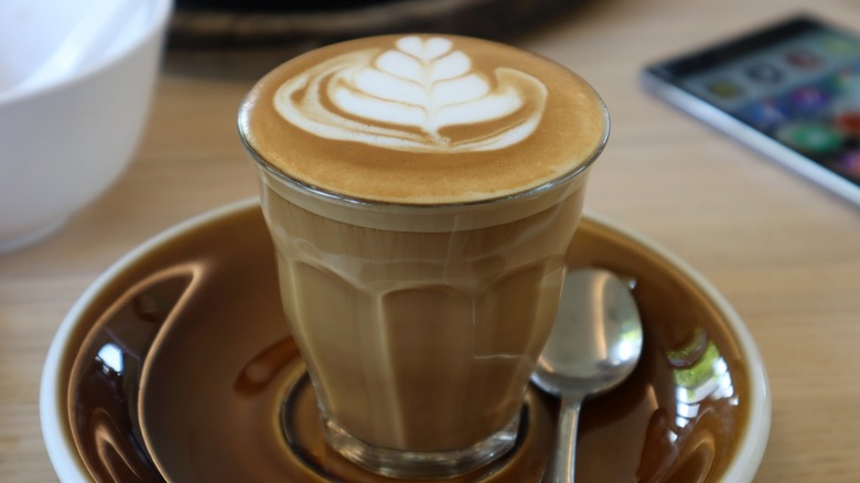 A piccolo with latte art in a saucer