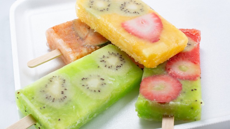 Four Mexican fruit paletas stacked on plate