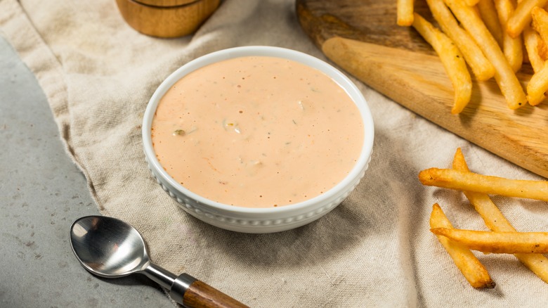 Dish of homemade spicy mayo beside a plate of fries