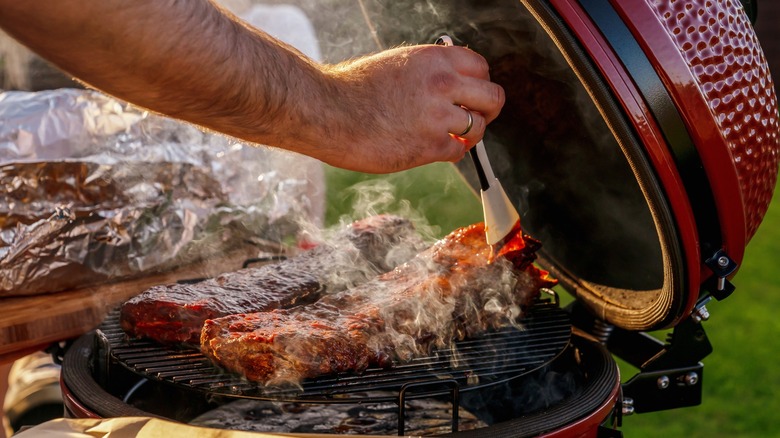 Hand marinating pork ribs in a ceramic smoker 