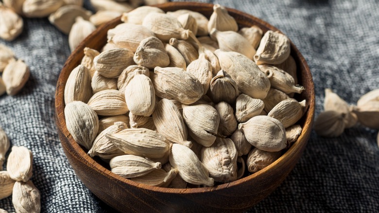 White cardamom seeds in a wooden bowl 