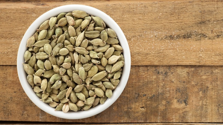 Top-down view of white cardamom seeds on a wooden table