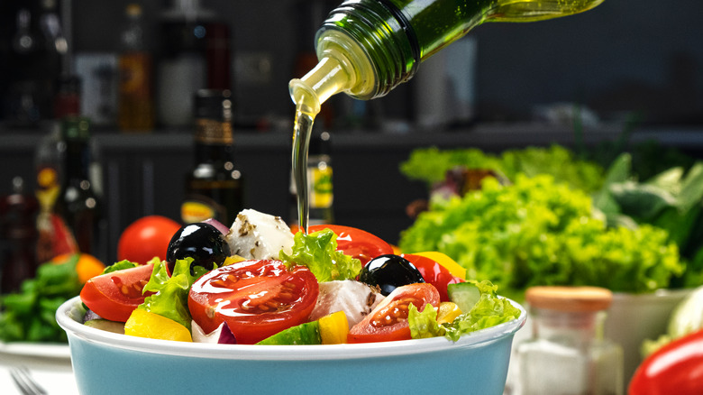 Olive oil being poured on salad