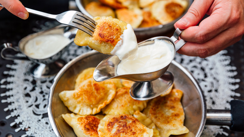 Dipping pierogis in sour cream