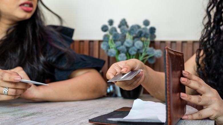 Friends paying for meal at restaurant