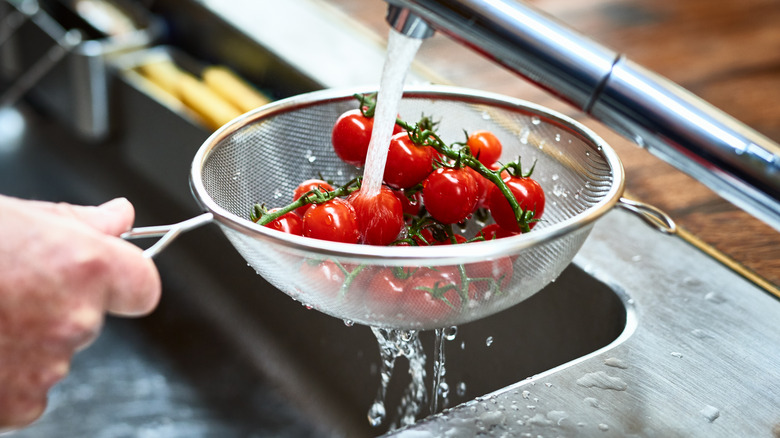 Rinsing cherry tomatoes in sink