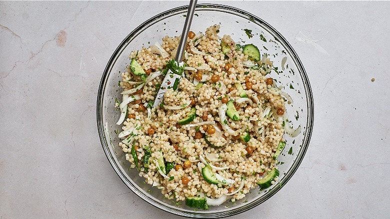 tossing salad in a bowl