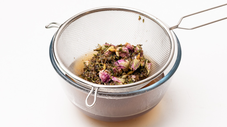 straining floral syrup through sieve