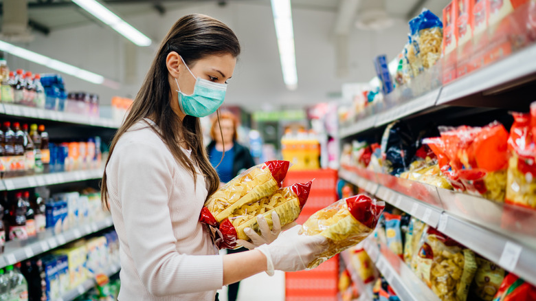 A woman shopping for pasta at a grocery store