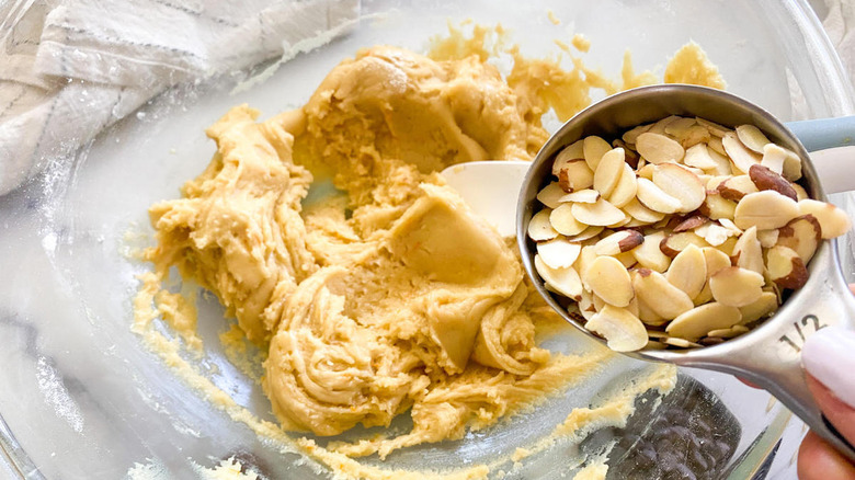 adding almonds to biscotti dough