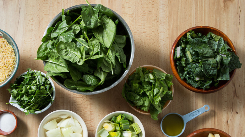 assorted leafy greens in bowls 