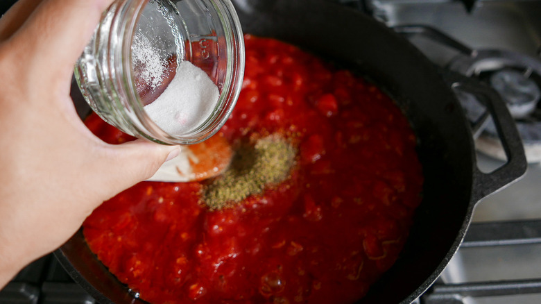 adding sugar to tomato sauce