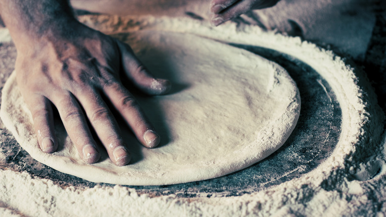 Chef stretching pizza dough 