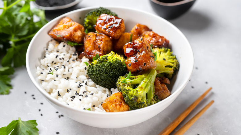 Tofu rice bowl with chopsticks on counter  