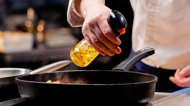 spraying cooking oil into a pan