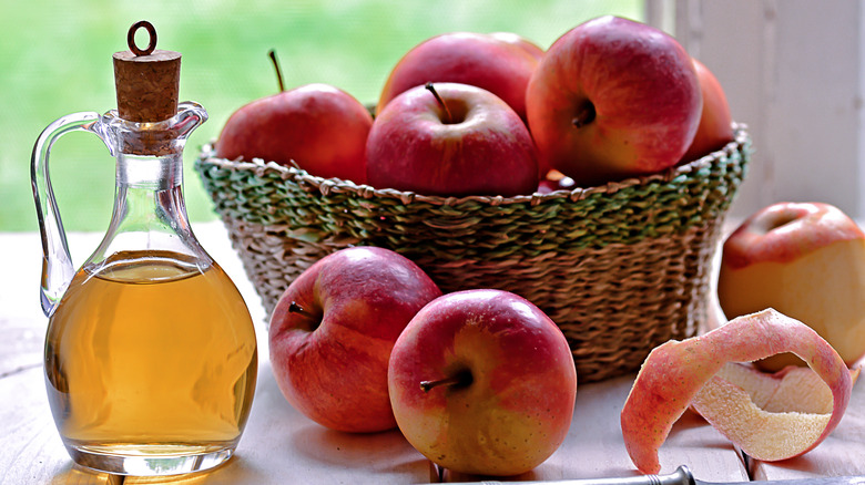 bottle of vinegar with basket of apples