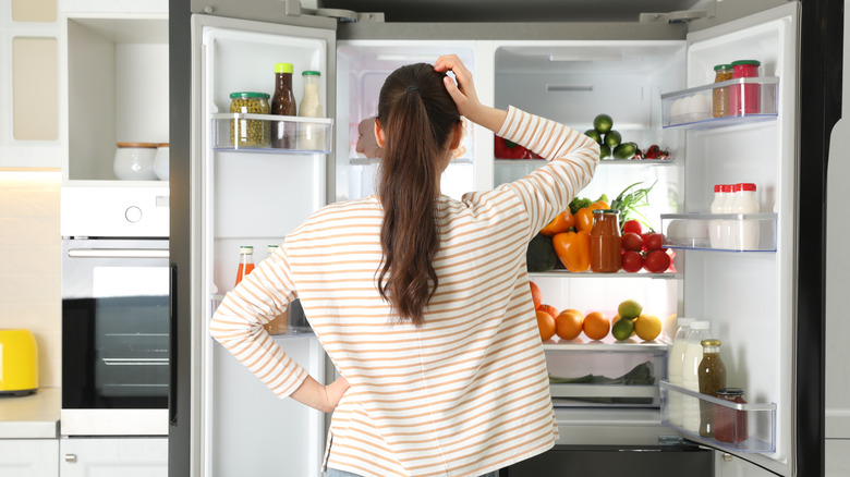 woman looking into refrigerator 