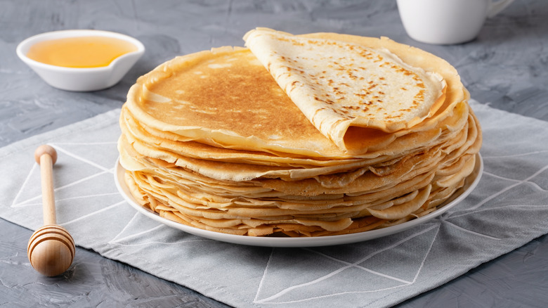 Plated stack of crepes with butter bowl