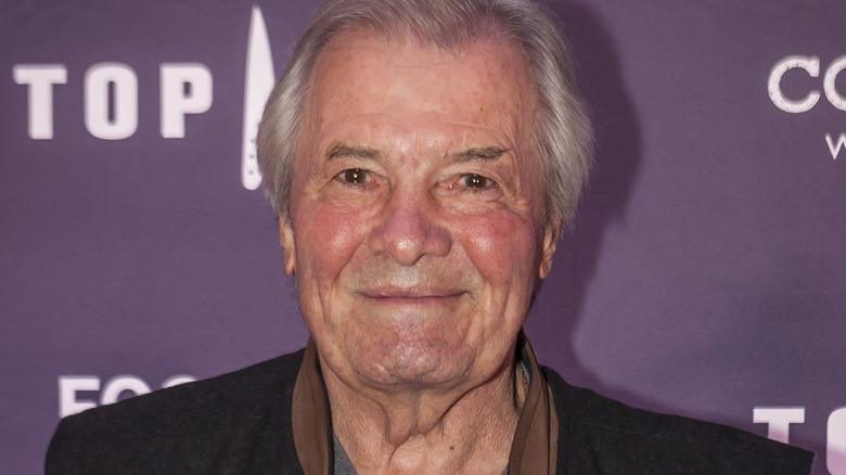 Jacques Pépin smiling in gray shirt and black vest