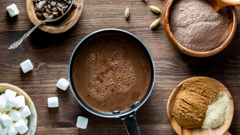 chocolate boiling in pot with small dishes