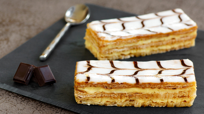 Mille-Feuille and chocolate squares on dark plate