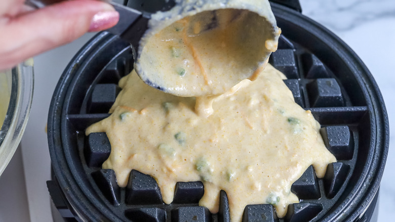 waffle batter being poured into a waffle iron