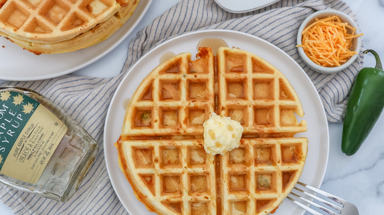 jalapeño cheddar waffles on a plate with butter and syrup