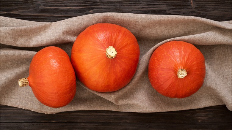 three Red Kuri squash on a cloth