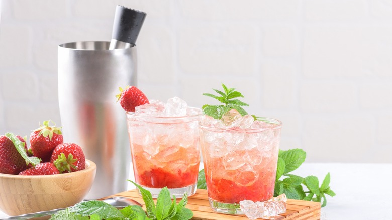 Two strawberry mojito cocktails with garnishing and muddler