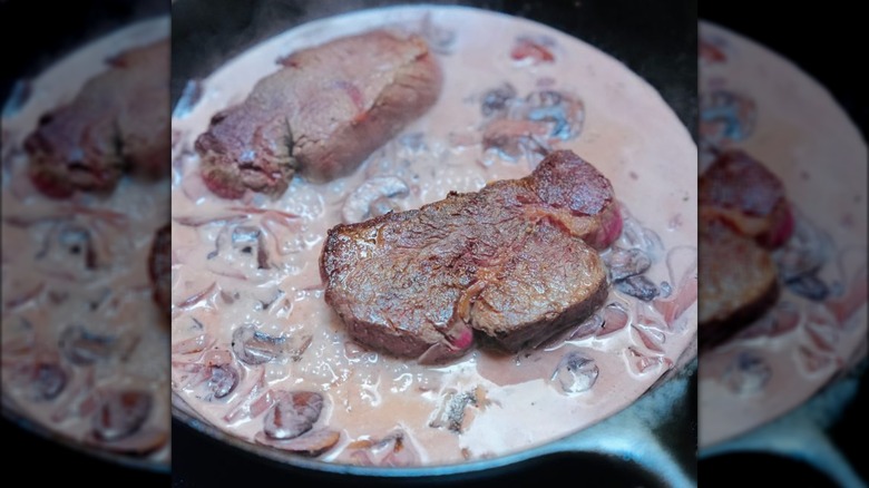 Meat cooking in a cream wine sauce