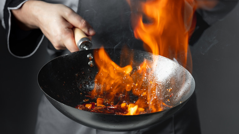 Stir frying ingredients in flaming wok