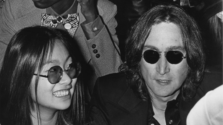 John Lennon and May Pang wearing sunglasses