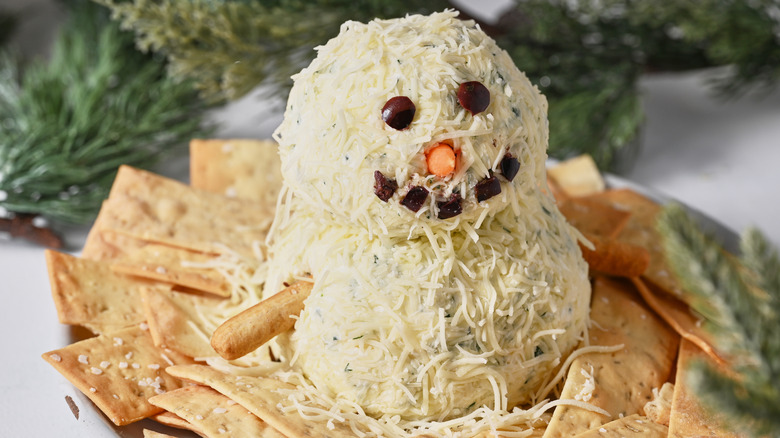 snowman cheese ball on plate with crackers