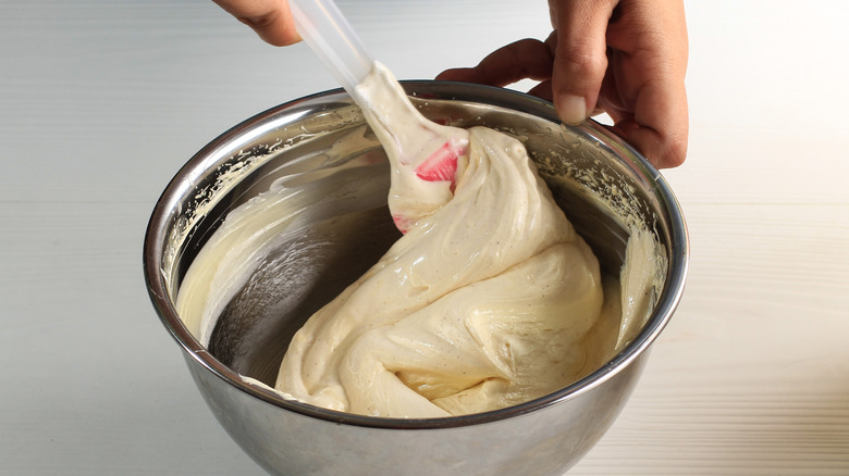 Person folding batter with rubber spatula