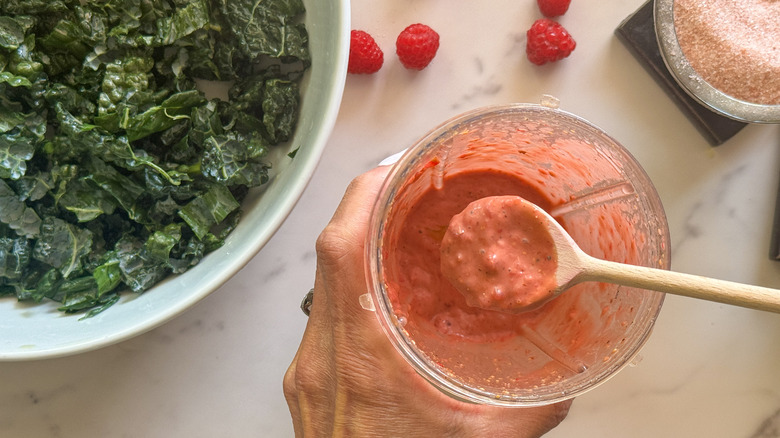 hand holding spoon with dressing