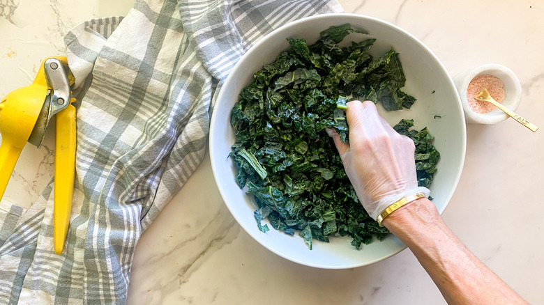 massaging kale in big white bowl