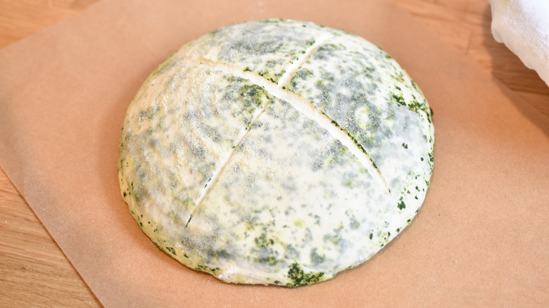 scoring pesto sourdough loaf