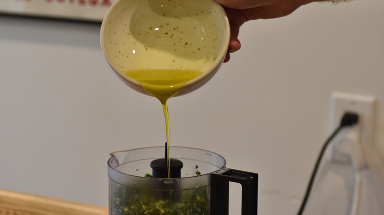 adding oil to pesto