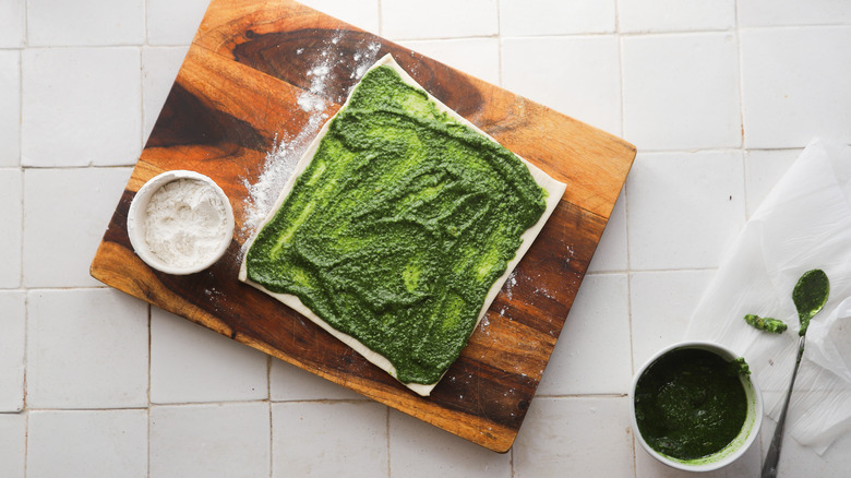 Pesto spread on raw dough