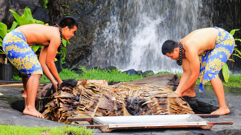 Two men covering an imu oven