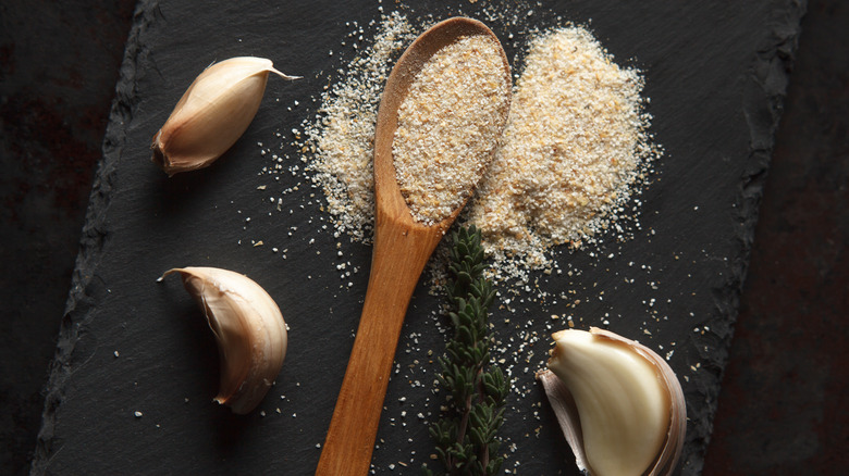 seasoning on wooden spoon and garlic cloves