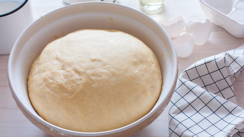 bread dough rising in a ceramic bowl 