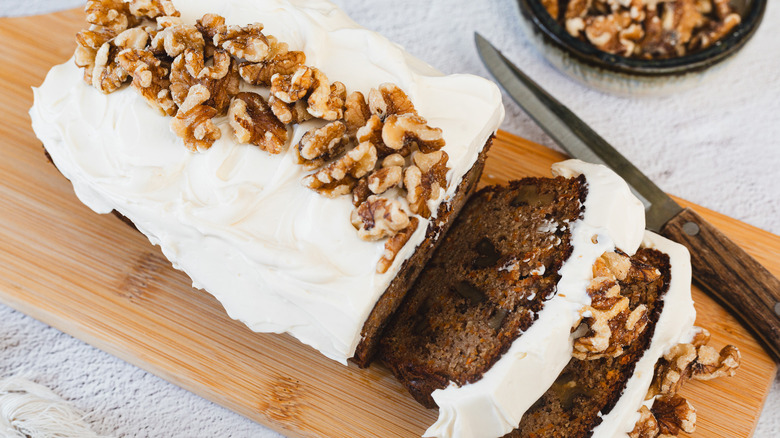 Sliced carrot cake with walnuts and knife