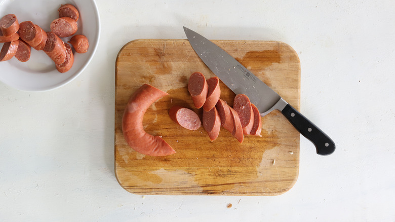 cut kielbasa on cutting board