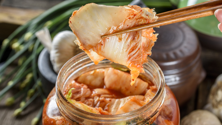 chopsticks taking kimchi from jar